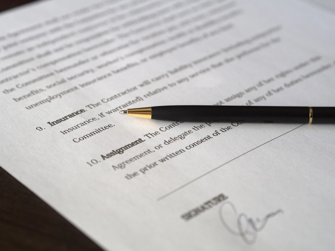Długopis i papierowa umowa leżące na stole.
