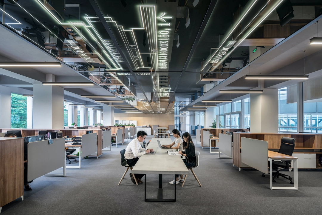 Zdjęcie przedstawiające dużą przestrzeń biurową wykończoną w nowoczesnym stylu.